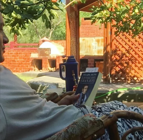 Debajo de la higuera en su casa de Centenario, leyendo la vida de San Martín